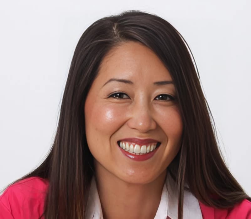 Jean Chan, DDS, smiling dental professional in pink and white attire against white background.